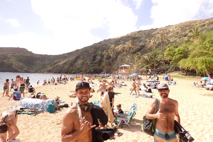 a group of people standing on top of a sandy beach